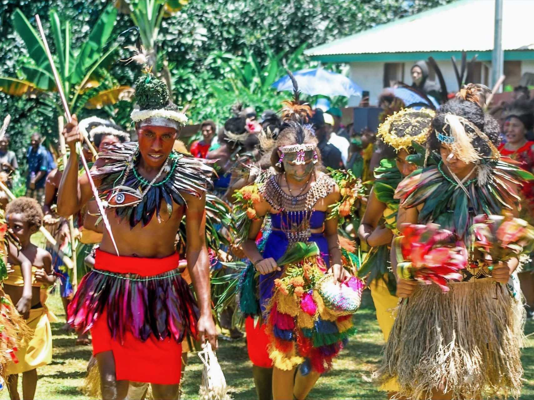 Students performing a traditional dance in feathers, leaves and grass skirts at the school cultural show.