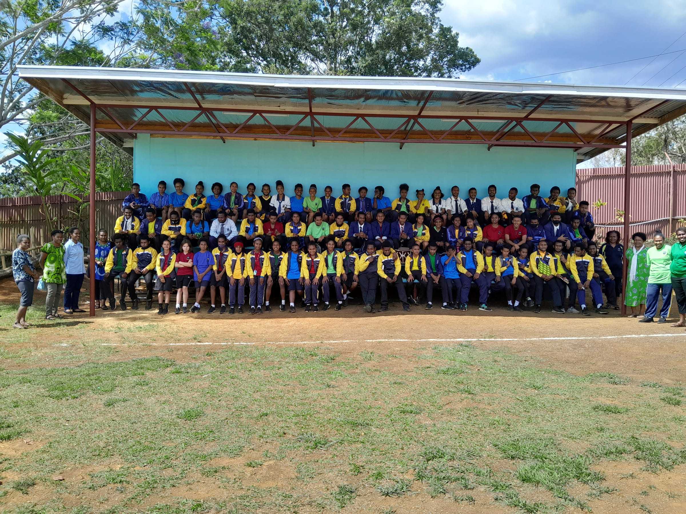 Students assembled in front of the covered stage on the Goroka campus.